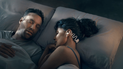 Couple sleeping, with the woman wearing Philips Sleep Headphones