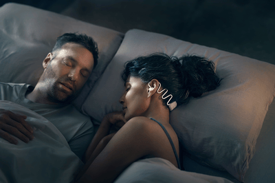 Couple dormant, la femme portant des écouteurs Philips Sleep