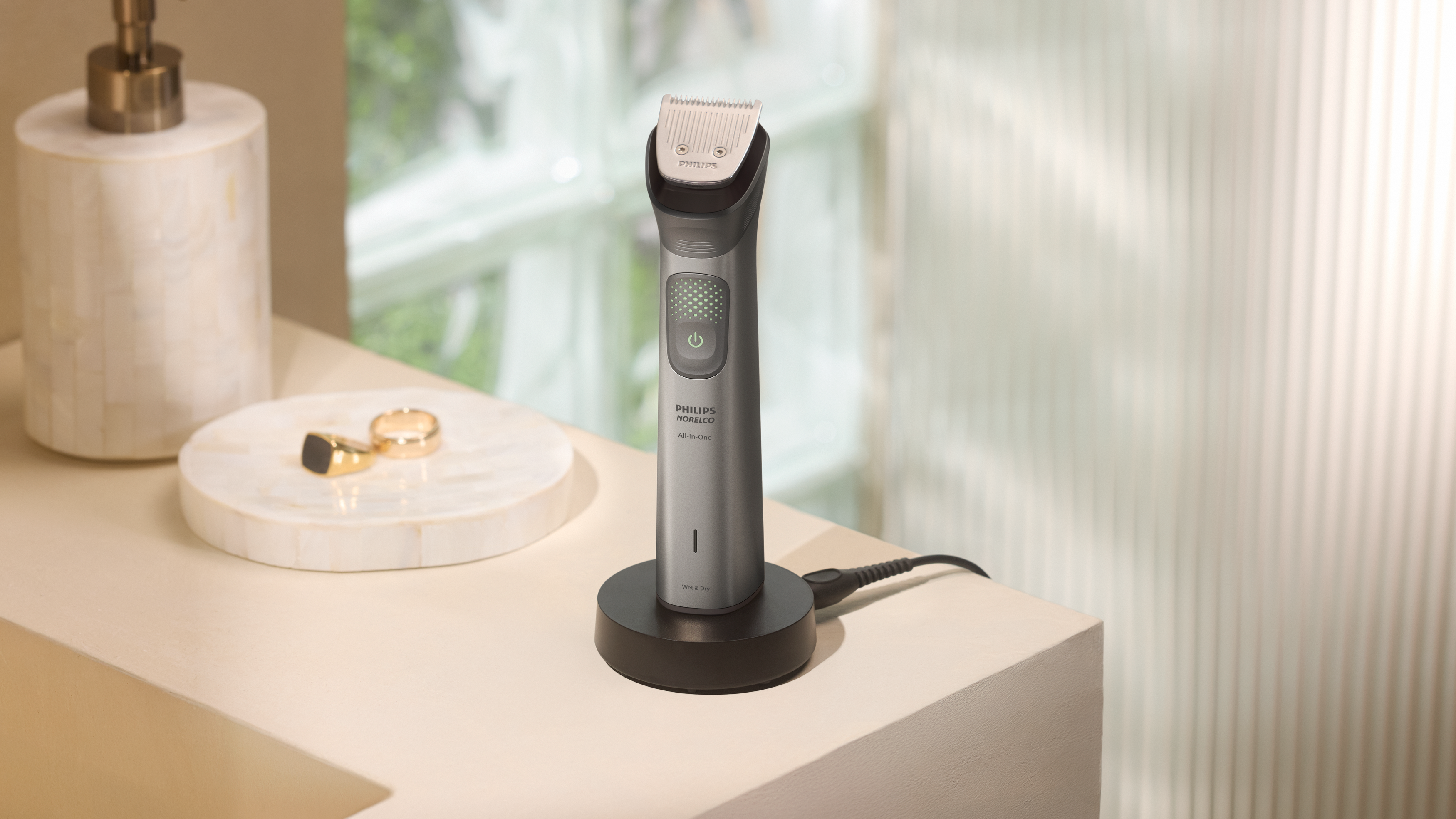 A Philips All-in-One Trimmer Series 9000 sits on a charging stand in a brightly lit bathroom.