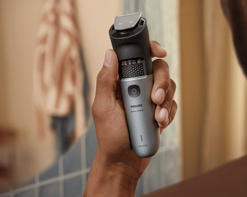 Man holds waterproof Beard Trimmer 7000 in shower