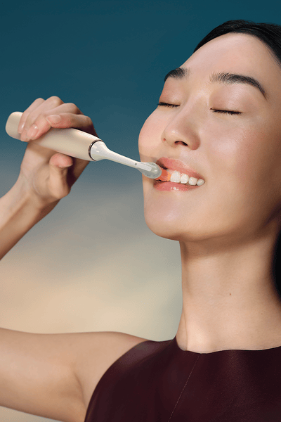 Image of woman brushing teeth.