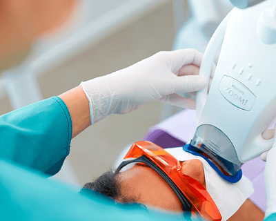 Patient with dentist having Zoom whitening treatment in office