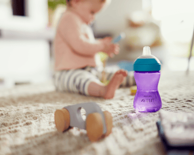 Bebê segurando um copo para crianças