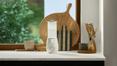 A Philips Avent bottle steriliser on a kitchen countertop in front of a window.
