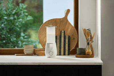 A Philips Avent bottle steriliser on a kitchen countertop in front of a window.