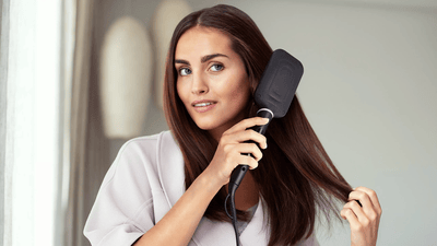 Person using a hair straightening brush