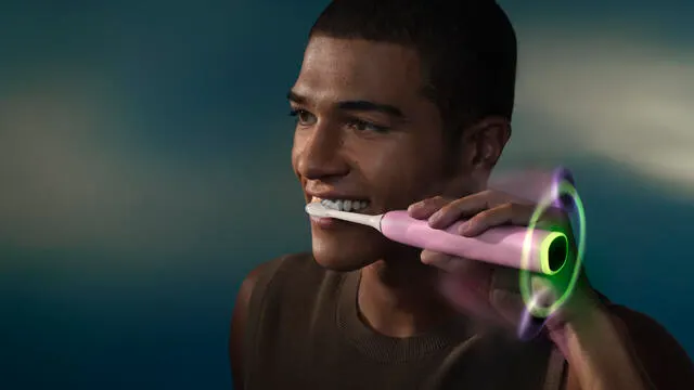 A young man brushes his teeth using a Philips Next-Generation DiamondClean electric toothbrush.