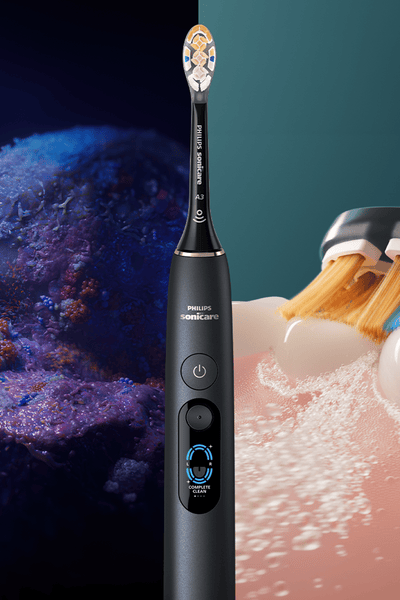 A composited image of bacteria and a sonicare toothbrush in action, seperated by a Ph...