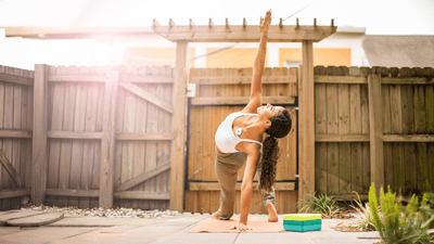 Mujer estirándose sobre una esterilla de yoga bajo la luz del sol
