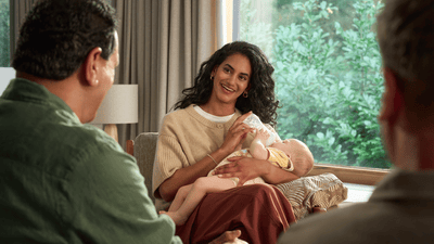 Picture of a woman feeding a baby with a sterilised baby bottle sitting on a comfortable chair.