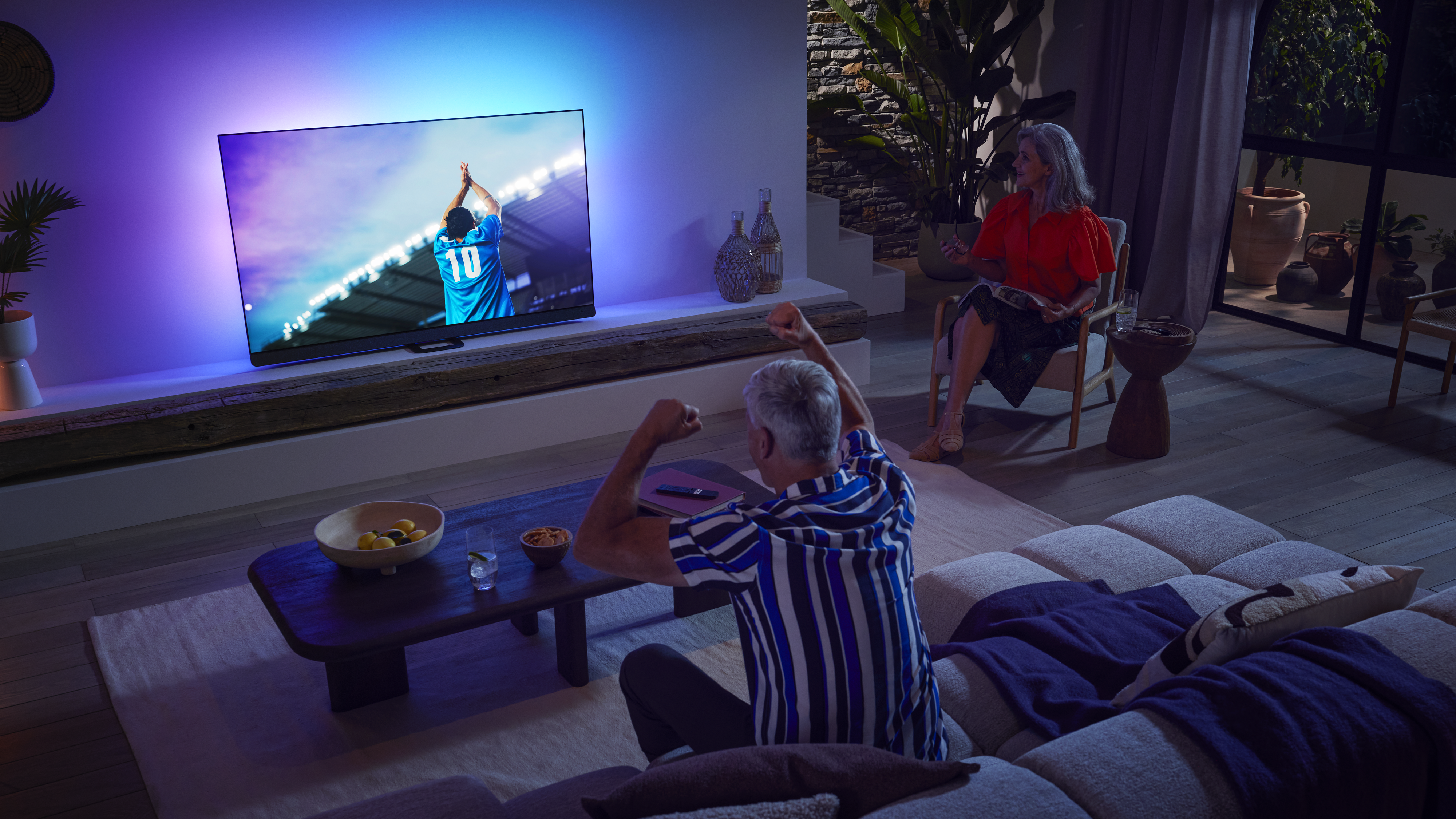 Οικογένεια παρακολουθεί έναν αγώνα σε τηλεόραση OLED.