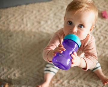 Baby holding a sippy cup