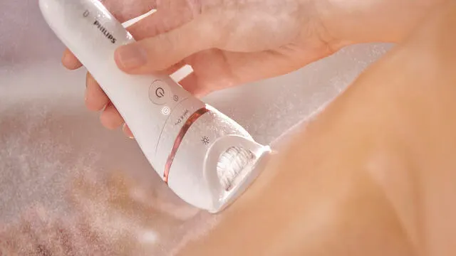 A close-up image of a Philips epilator being used to remove hair from skin.