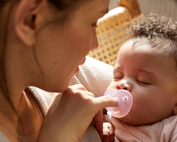 Baby smiling while holding a snuggle