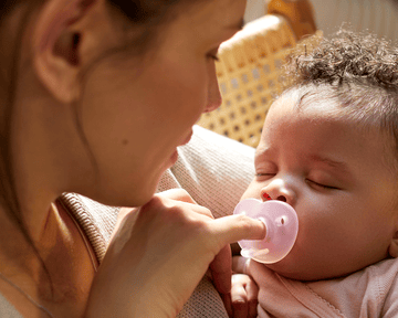 Baby smiling while holding a snuggle