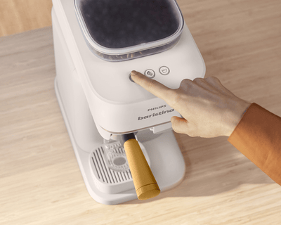 Philips Baristina machine brewing espresso on a table