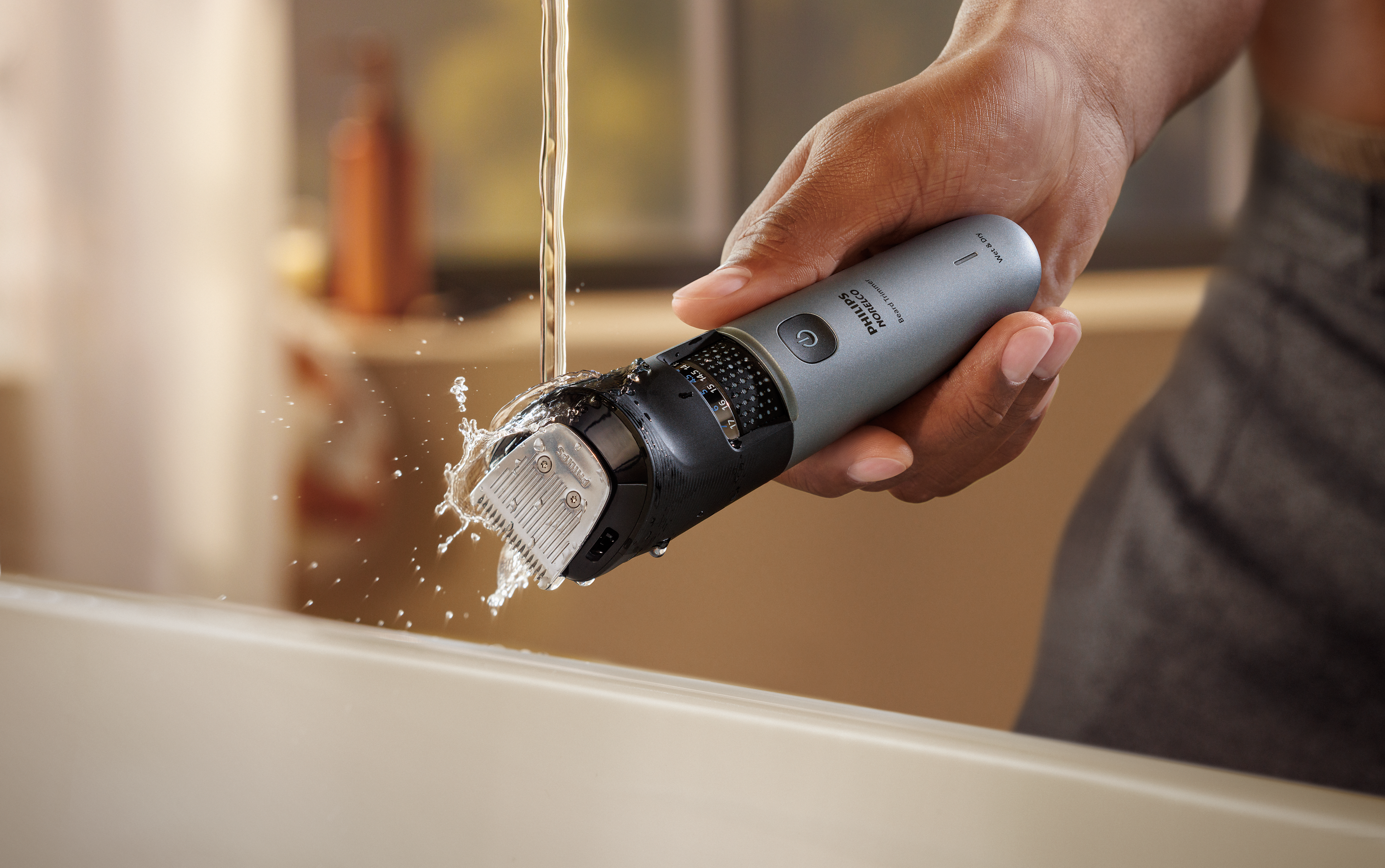 Man rinsing trimmer attachments under water