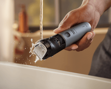 Man rinsing trimmer attachments under water