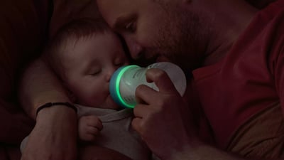 Niemowlę pijące z butelki z fluorescencyjnym smoczkiem Philips Avent