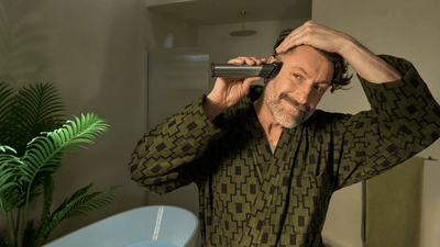 Muž stříhá vlasy multifunkčním zastřihovačem