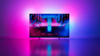Philips Ambilight TV prikazuje koncertnu scenu s ružičastim i plavim ambijentalnim svjetlom.