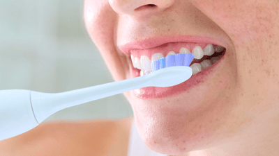 A close-up of a woman brushing her teeth.