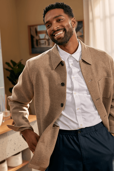 Man smiling in mirror with freshly trimmed beard