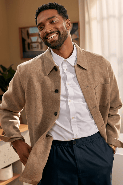Homme souriant face au miroir avec une barbe fraîchement taillée