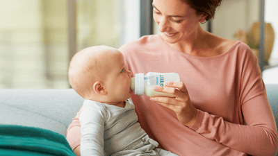 Mama kŕmi dieťa s detskou fľašou Philips