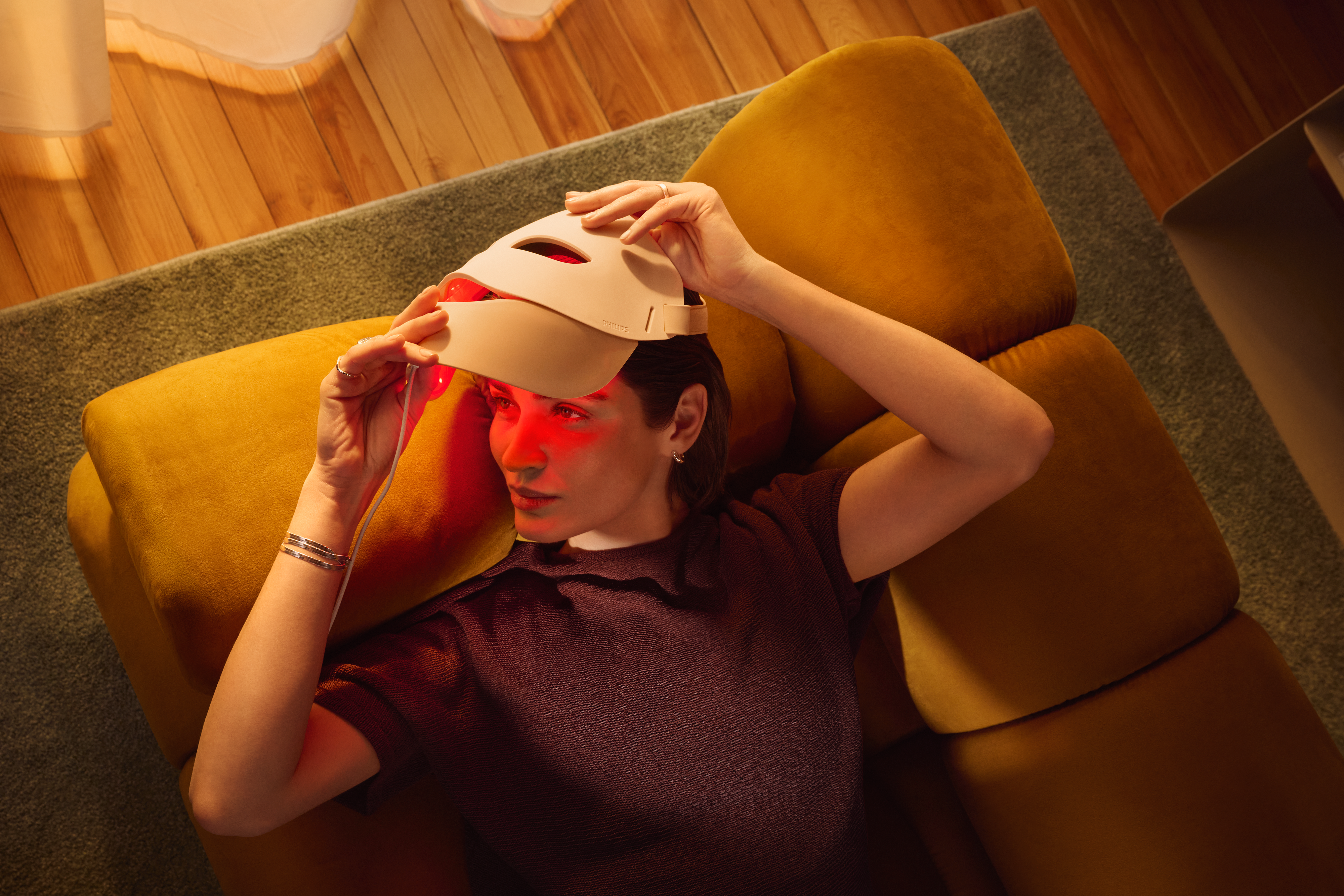 Person using Philips LED Face Mask in Age Care mode with red light therapy