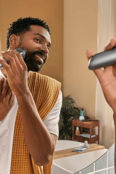 Man som trimmar ett helskägg med Philips skäggtrimmer 7000