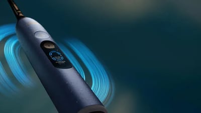 A navy blue Philips Next-Generation DiamondClean electric toothbrush against a dark gradient background.
