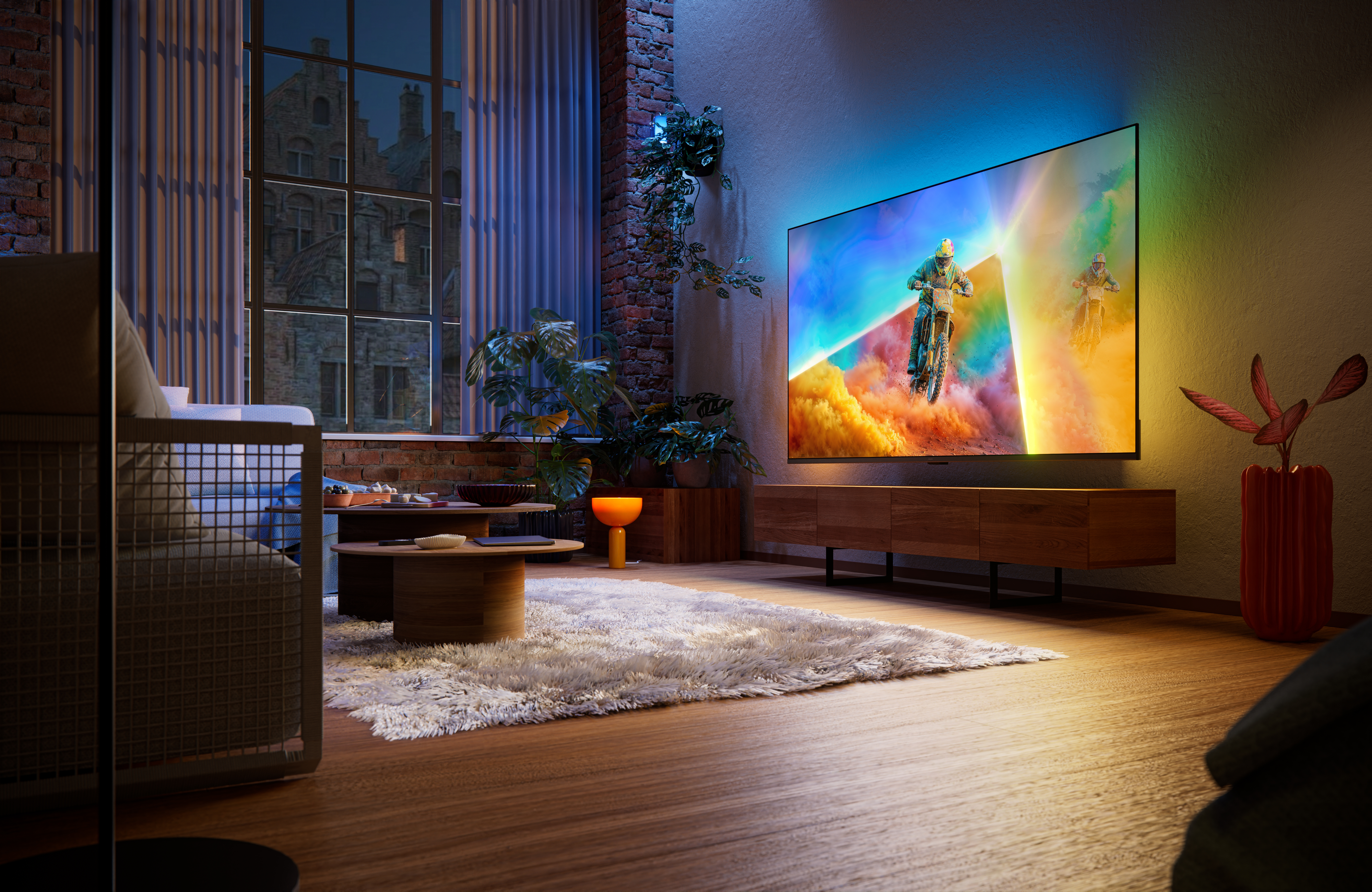 Philips Ambilight TV in a contemporary living room, displaying a motocross racing scene with colorful ambient lighting extending beyond the screen and illuminating the surrounding wall.Philips Ambilight TV in a contemporary living room, displaying a motocross racing scene with colorful ambient lighting extending beyond the screen and illuminating the surrounding wall.