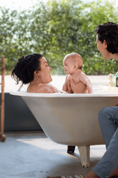 A baby in the bath with two women
