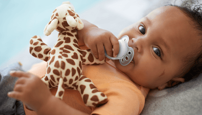 Bebeluș ține fericit suzeta