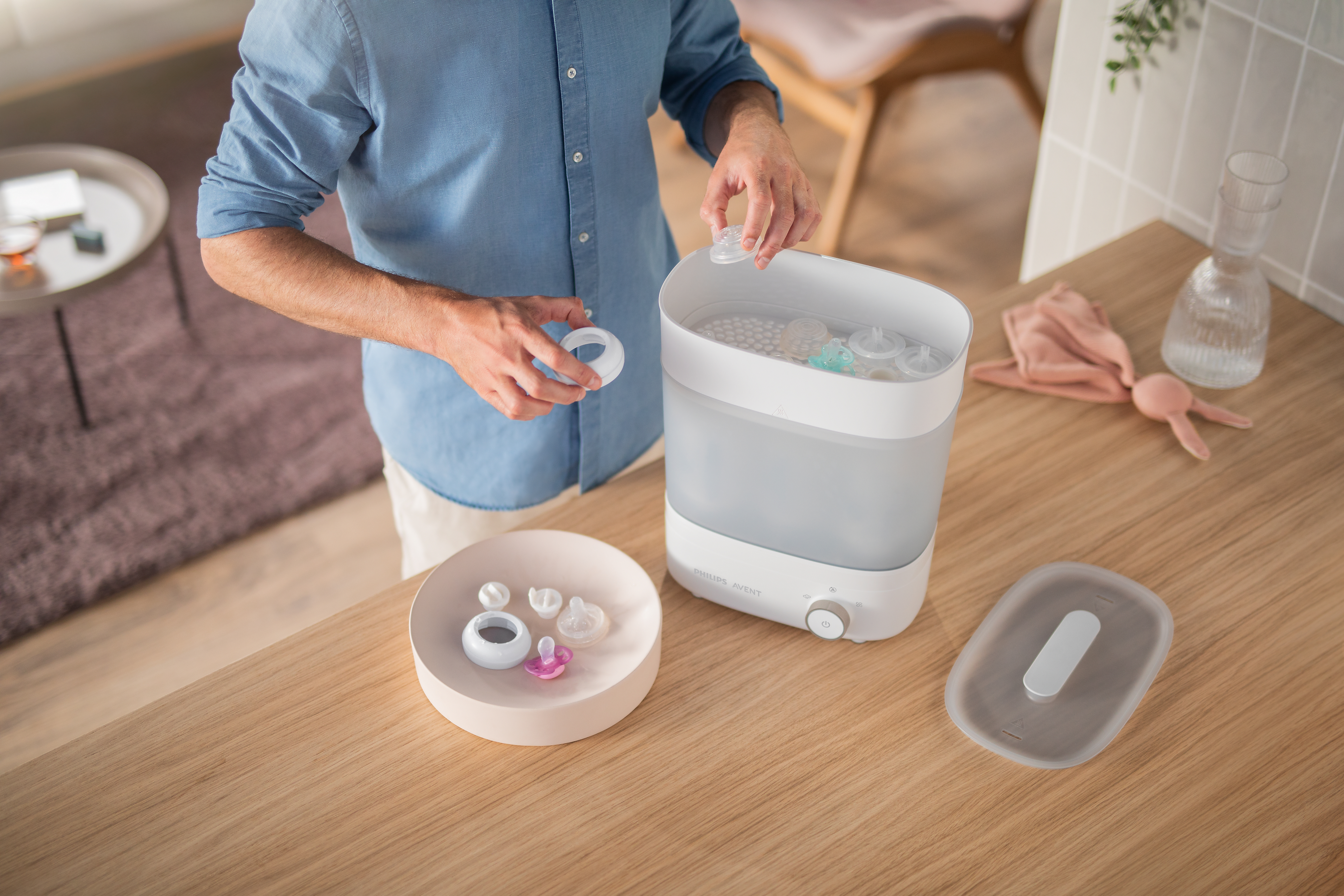 Man putting bottles and pacifiers into the sterilizer
