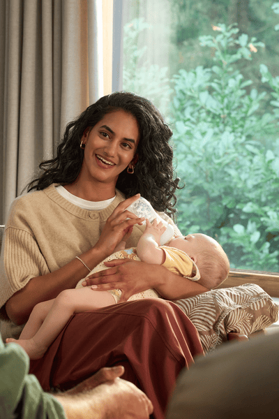 אמא מאכילה תינוק עם בקבוק מחומם ומחוטא