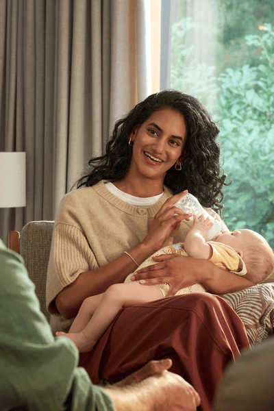 Mor mader baby med en varm, steriliseret flaske