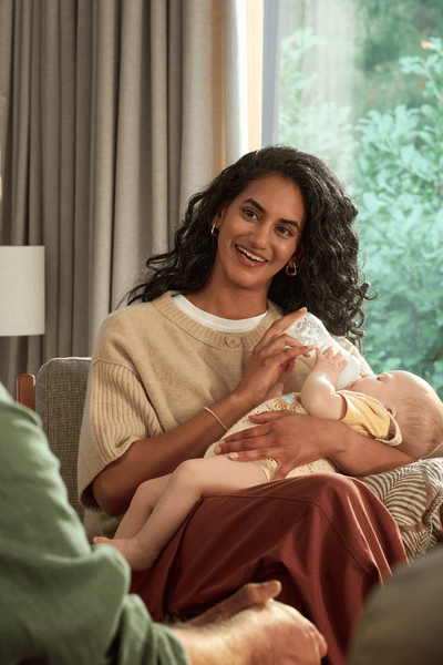 אמא מאכילה תינוק עם בקבוק מחומם ומחוטא