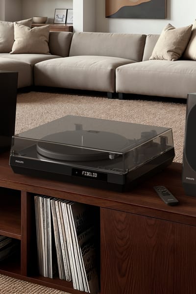 Bezdrátový reproduktor Philips na polici v útulném obývacím pokoji