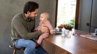 Tata z maluchem i butelka Philips Avent w tle