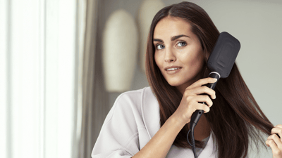 Woman styling hair with curling iron