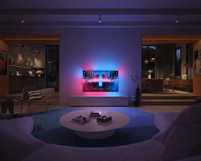 Philips Ambilight Fernseher strahlt blaues und pinkes Licht in ein modernes, dunkel beleuchtetes Wohnzimmer.