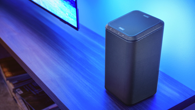 Philips FS1 bežični zvučnik postavljen na TV stalak s plavom ambijentalnom rasvjetom