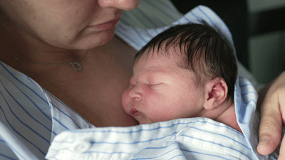 Close-up of tender mother-baby skin contact