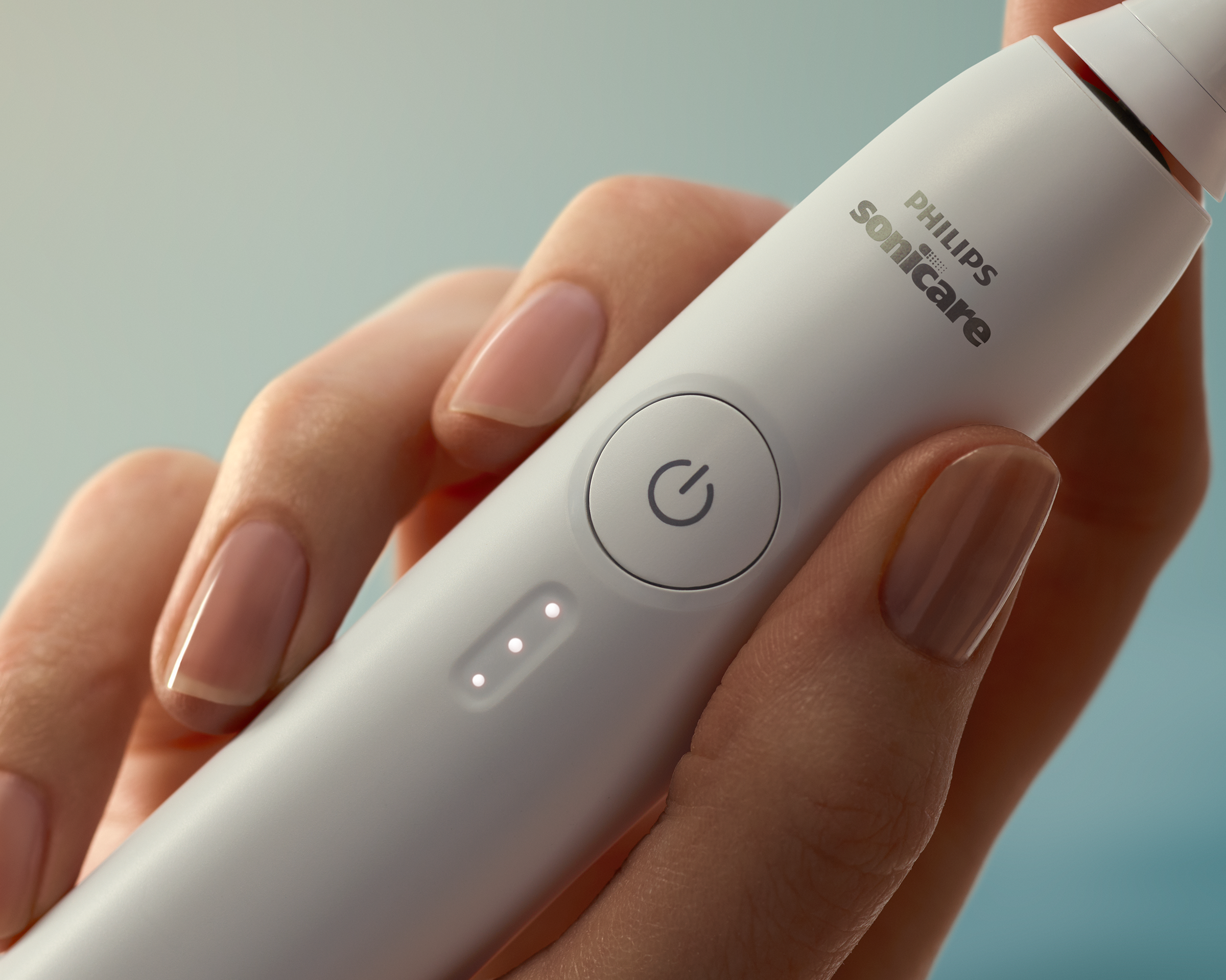 Hand die de Sonicare 3000 vasthoudt met verlichte knoppen.
