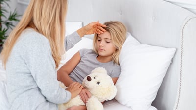 Mamă care îngrijește copilul și îi verifică fruntea