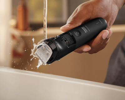 Man rinsing trimmer attachments under water