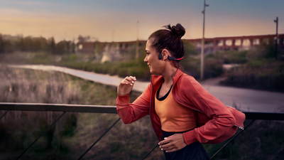 Športovec používajúci slúchadlá na kostné vedenie zvuku pri behu vonku