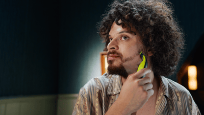 Primo piano di un uomo che si sistema la barba con un rasoio OneBlade